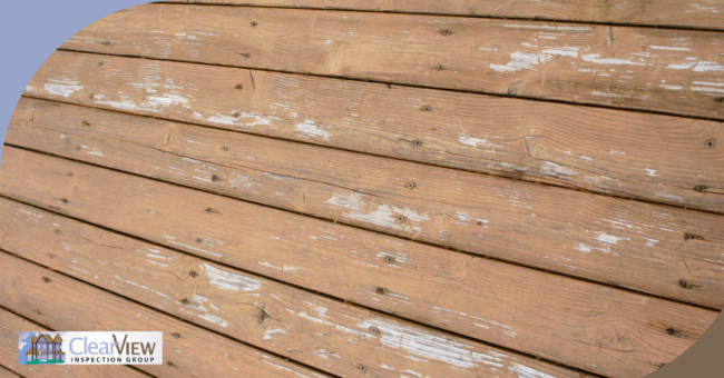 Clear View Inspection Group Weathered wooden deck boards with peeling paint and signs of aging.